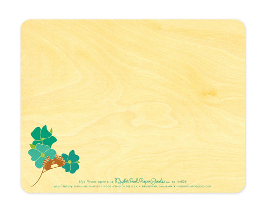 Back of Blue Flower Squirrels wood love card, which features a small version of the front design at in the lower left corner and plenty of space to write a personal greeting. Along the bottom is the company logo and text that reads "eco-friendly sustainably harvested wood - made in the usa - birmingham, owlabama - nightowlpapergoods.com"