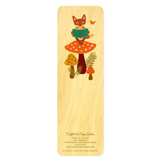 Back side of wooden bookmark with fox sitting on a big mushroom reading a book