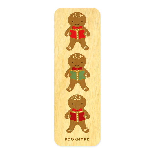 Front of Gingerbread birch wood mini bookmark with rounded corners, featuring three smiling gingerbread cookies holding red and green books with decorative details. Text at bottom reads "BOOKMARK."